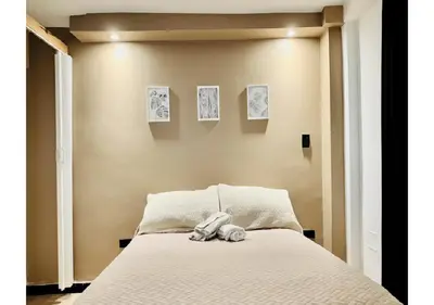 a teddy bear sitting on top of a bed at Apartaestudio Medellin - Santa Lucia in Medellín