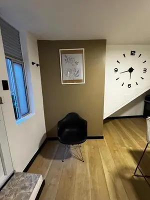a room with a clock on the wall and a chair at Apartaestudio Medellin - Santa Lucia in Medellín