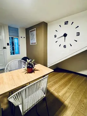 a room with a clock and a table and chairs at Apartaestudio Medellin - Santa Lucia in Medellín