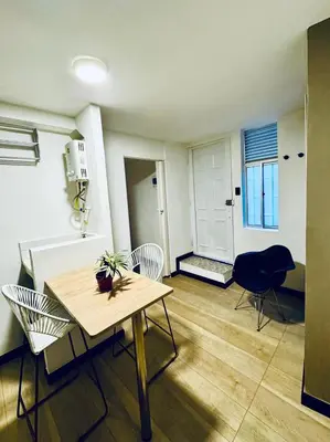 a living room with a table and chairs in a room at Apartaestudio Medellin - Santa Lucia in Medellín