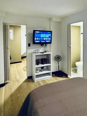 a bedroom with a flat screen tv on the wall at Apartaestudio Medellin - Santa Lucia in Medellín