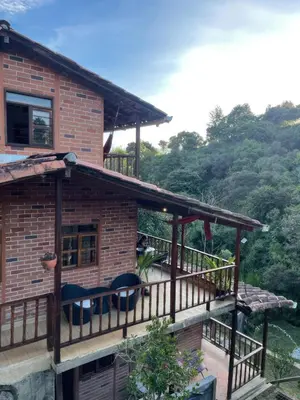 a house with a deck with chairs on it at Finca Acogedora con Área de BBQ, Parking Privado y Hamacas in Guarne