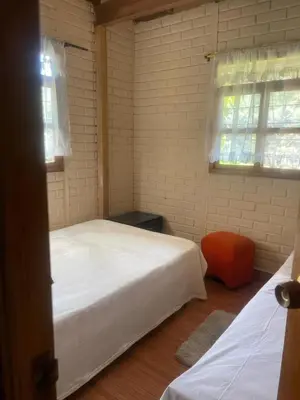 a bedroom with two beds and an orange chair at Finca Acogedora con Área de BBQ, Parking Privado y Hamacas in Guarne