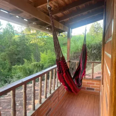 a hammock hanging on a balcony with a view at Finca Acogedora con Área de BBQ, Parking Privado y Hamacas in Guarne