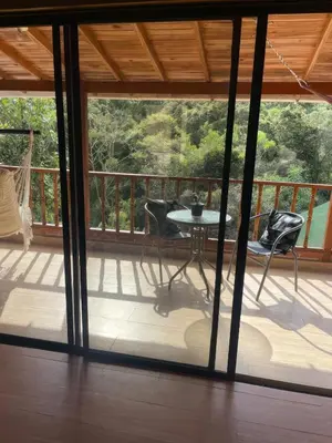 a screened in porch with a table and chairs at Finca Acogedora con Área de BBQ, Parking Privado y Hamacas in Guarne