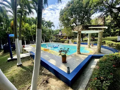 a swimming pool in a resort with a blue floor at Finca Balvanera in Sopetran