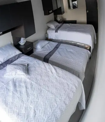 two beds in a hotel room with a mirror at Apartamento a 15 minutos Aeropuerto y Rionegro in Rionegro