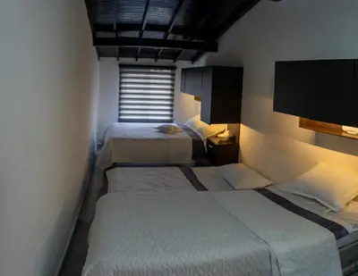 a hotel room with two beds and a window at Apartamento a 15 minutos Aeropuerto y Rionegro in Rionegro