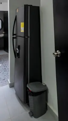 a refrigerator in a kitchen with a trash can at Apartamento a 15 minutos Aeropuerto y Rionegro in Rionegro