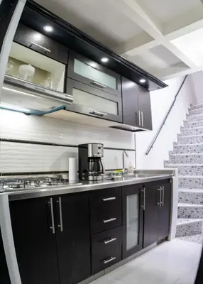 a kitchen with black cabinets and stainless steel appliances at Apartamento a 15 minutos Aeropuerto y Rionegro in Rionegro