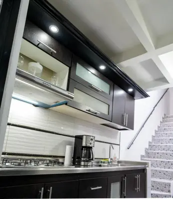 a kitchen with black cabinets and a coffee maker at Apartamento a 15 minutos Aeropuerto y Rionegro in Rionegro