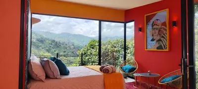 a bedroom with a bed and a balcony with a view at Glamping Raíces in Manizales
