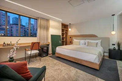 a bedroom with a bed and a desk and a chair at LIN Boutique Hotel by HOUSY in Medellín