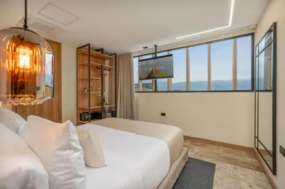 a bedroom with a white bed and a large window at LIN Boutique Hotel by HOUSY in Medellín