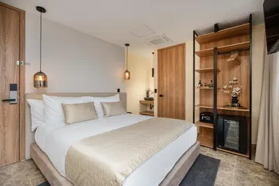 a bedroom with a large white bed and a television at LIN Boutique Hotel by HOUSY in Medellín