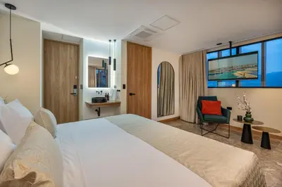 a hotel room with a large bed and a chair at LIN Boutique Hotel by HOUSY in Medellín