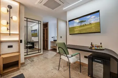 a living room with a fireplace and a tv on the wall at LIN Boutique Hotel by HOUSY in Medellín