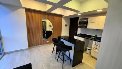 a kitchen with a bar with stools and a mirror at 2103 Apto de lujo Poblado Medellín in Medellín