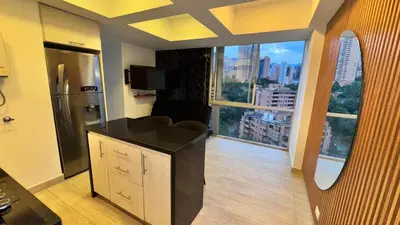 a kitchen with a refrigerator and a large window at 2103 Apto de lujo Poblado Medellín in Medellín