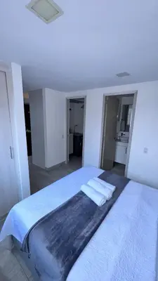 a white bedroom with a bed with two towels on it at 2103 Apto de lujo Poblado Medellín in Medellín
