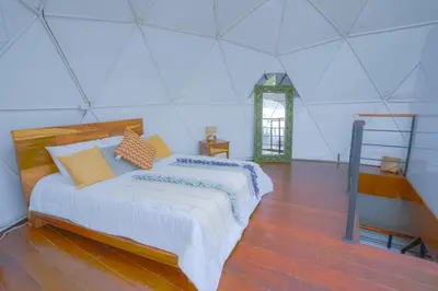 a bedroom with a bed and a ladder in it at Cinco Elementos in El Peñol