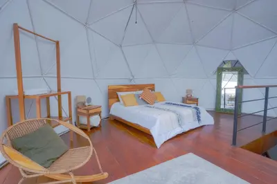a bedroom with a bed and a chair at Cinco Elementos in El Peñol