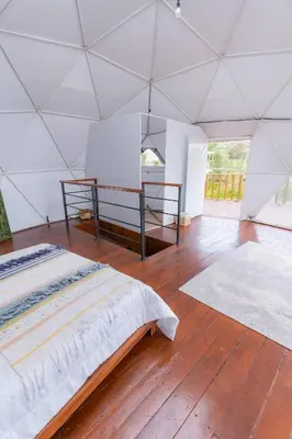 a large white room with a bed in a tent at Cinco Elementos in El Peñol