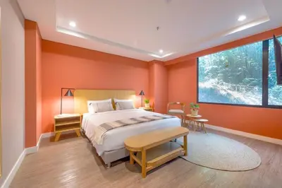 a bedroom with orange walls and a bed and a window at Modern Comfort in El Tesoro Medellín 301 in Medellín
