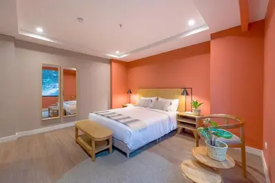 a bedroom with orange walls and a bed and a table at Modern Comfort in El Tesoro Medellín 301 in Medellín