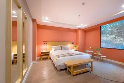 a bedroom with orange walls and a bed and a table at Modern Comfort in El Tesoro Medellín 301 in Medellín