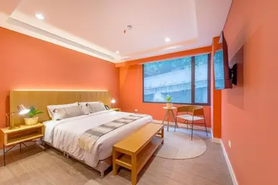 a bedroom with orange walls and a bed and a table at Luxury Escape by El Tesoro Perfect Location 302 in Medellín
