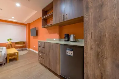 a kitchen with orange walls and a counter in a room at Luxury Escape by El Tesoro Perfect Location 302 in Medellín