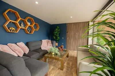 a living room with a couch and a blue wall at Beautiful cabin Guatapé vista-acceso al lago in La Pradera