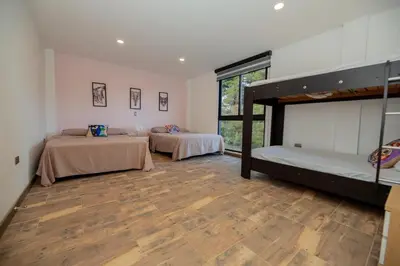 a room with two bunk beds and a wooden floor at Beautiful cabin Guatapé vista-acceso al lago in La Pradera