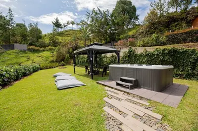 a hot tub and a gazebo in a yard at Beautiful cabin Guatapé vista-acceso al lago in La Pradera