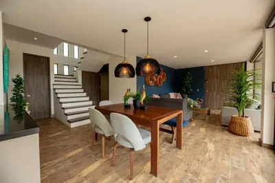 a dining room with a wooden table and white chairs at Beautiful cabin Guatapé vista-acceso al lago in La Pradera