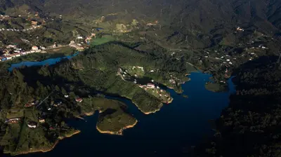 an aerial view of a river and a city at EL NiDO HOTEL GUATAPE in Guatapé