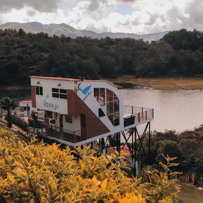 a building sitting on the side of a lake at EL NiDO HOTEL GUATAPE in Guatapé