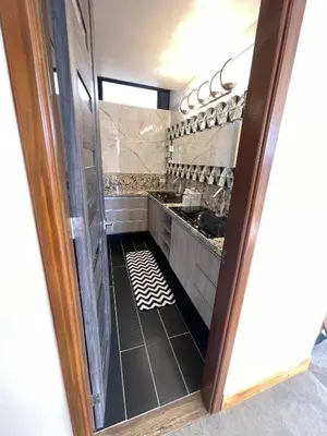 a kitchen with a door open to a room at EL NiDO HOTEL GUATAPE in Guatapé