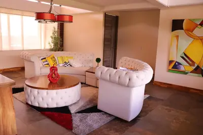 a living room with two white couches and a table at EL NiDO HOTEL GUATAPE in Guatapé