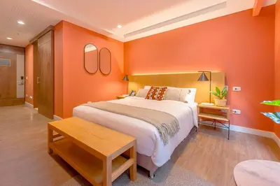 a bedroom with orange walls and a large bed at Elegant Stay Steps from El Tesoro Mall 304 in Medellín