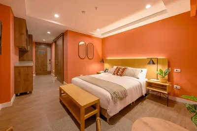 a bedroom with a large bed and orange walls at Elegant Stay Steps from El Tesoro Mall 304 in Medellín