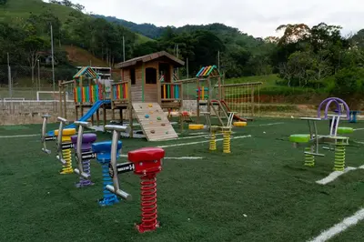 a playground with colorful play equipment in a field at Camping bajo techo y con estilo in San Rafael