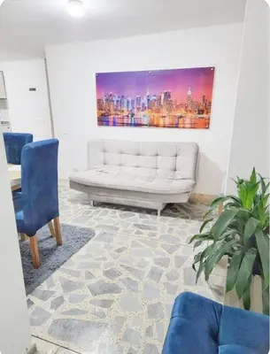 a living room with a white couch and a painting at exclusive apartment in laureles Estadio in Medellín