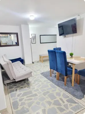 a living room with a table and chairs and a tv at exclusive apartment in laureles Estadio in Medellín