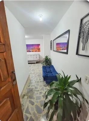 a living room with a blue couch and a plant at exclusive apartment in laureles Estadio in Medellín