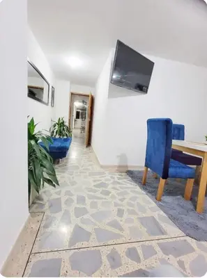 a living room with a table and a blue chair at exclusive apartment in laureles Estadio in Medellín