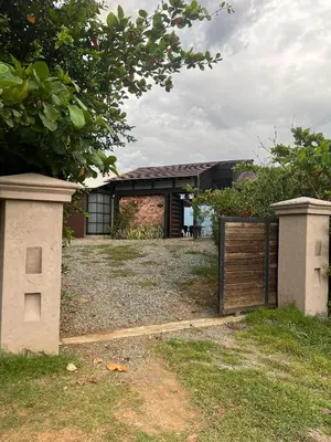 a house with a wooden gate in the yard at Cabaña en Santa Fe de Antioquia in Santa Fe de Antioquia