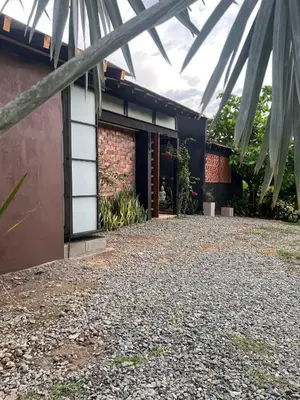 a house with a gravel driveway in front of a building at Cabaña en Santa Fe de Antioquia in Santa Fe de Antioquia