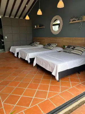 a group of three beds in a room with a mirror at Cabaña en Santa Fe de Antioquia in Santa Fe de Antioquia